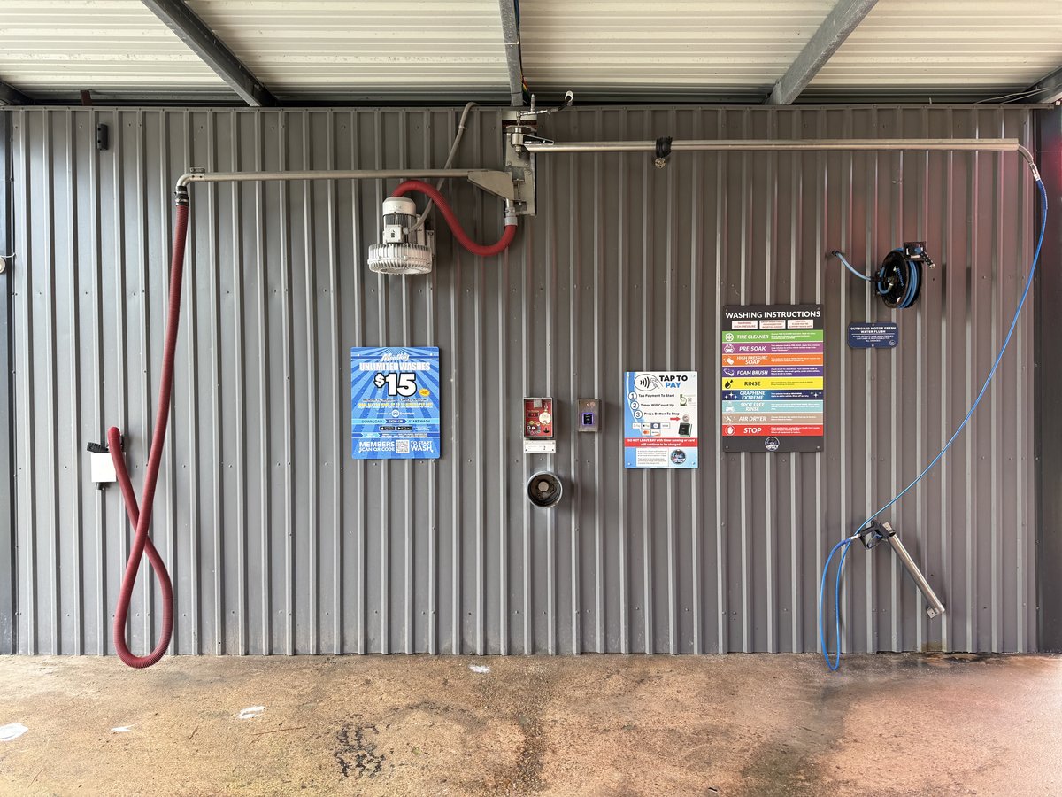 Self-serve wash bay at Gilbert's Car Wash Dickinson — high-pressure wand and foaming brush