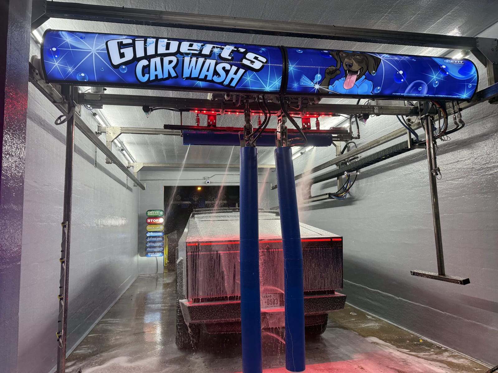 Touchless automatic wash applying presoak in the evening at Gilbert's Car Wash Victoria.